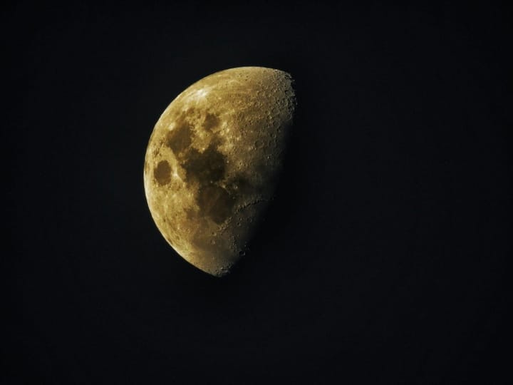 a big gold last quarter moon on a black sky